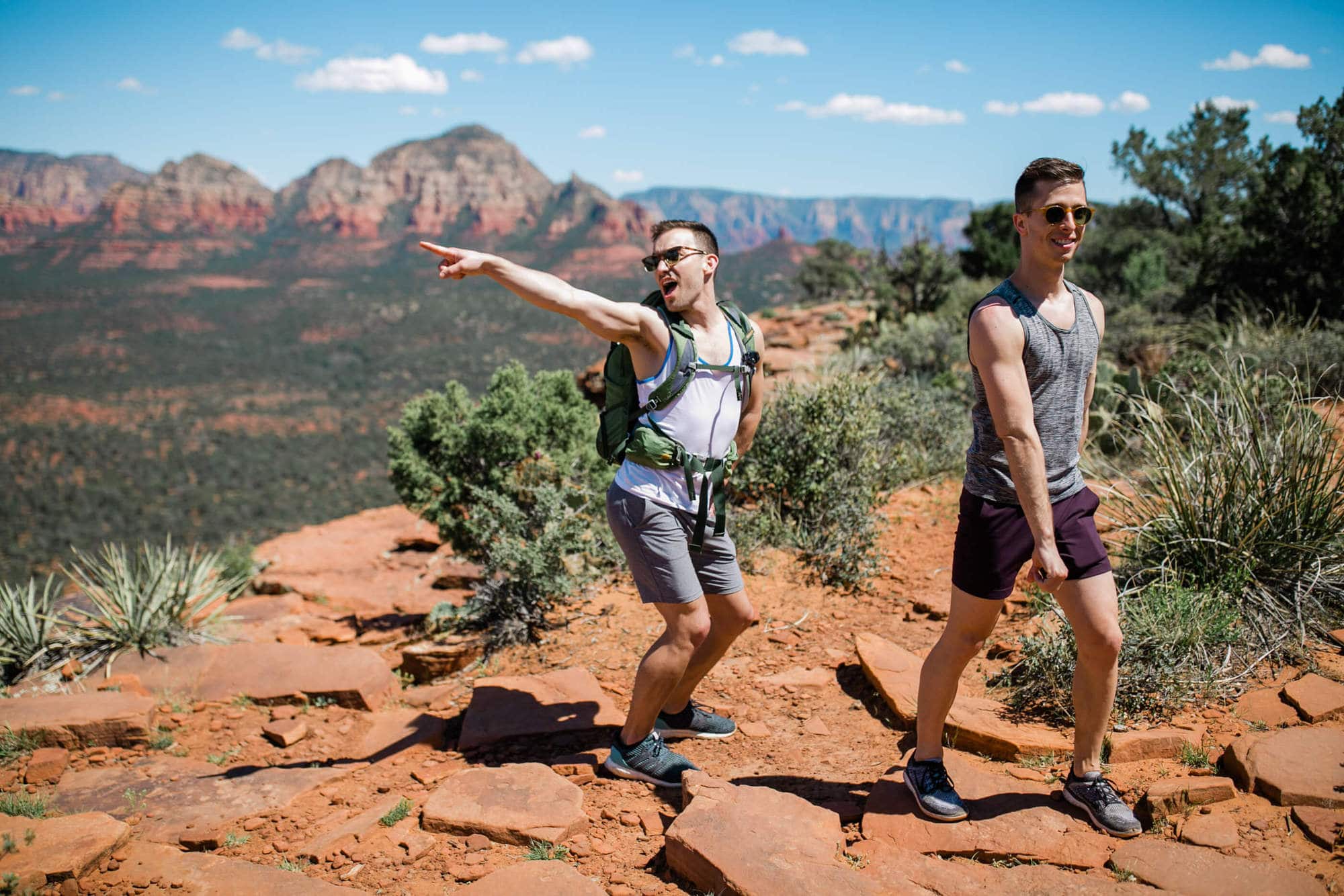 Michael and Todd visited from Chicago in April, which in the midwest is a month that feels like it should be gearing up towards summer but always somehow winds up more like winter. They requested epic views and fun hikes so, jamming as much into the experience we drove north to Sedona and then later to Page (check out next week’s blog for part II!). This is part I: Micheal and Todd’s Hiking Adventure in Sedona Arizona. So. I talk a lot about Peak Existence here at Aimee Flynn Photo. My mantra is, yes there will be epic photos but more than that you will have a fricken blast. And oh, boy, did we all have a blast. These two were up for absolutely everything and had a time and half doing it all, whether we were driving to our hiking spots and belting out show tunes, butt-scooting down a VERY steep trail, or snorting into a very protein forward lasagna. Michael and Todd were pretty unfamiliar with the desert landscape, which I took as a sort of personal challenge to blow their minds as much as possible and it was SO FUN watching them experience my favorite places with fresh eyes. We started the day off with one of my favorite hikes (which I took a very photojournalism approach too- this was Michael and Todd’s first introduction to Sedona so my goal was just to capture their authentic wonder and fun at the crazy new landscape). Antics ensued, which honestly turned into a theme of the trip.