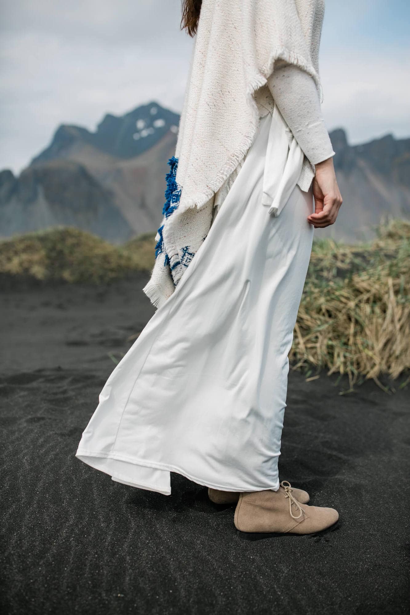 Details of iceland bride standing on a sand dune on a black sand beach.