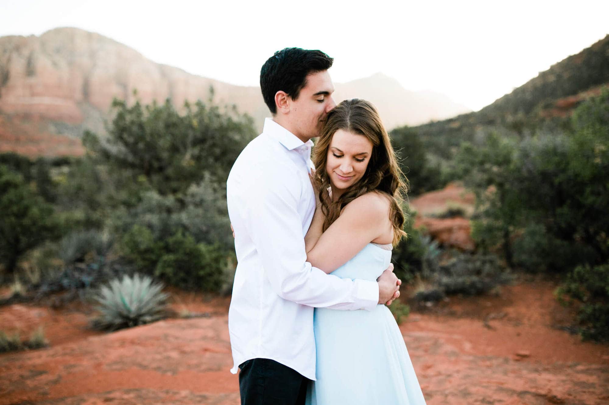 The groom kisses his bride's head during their epic sedona elopement.