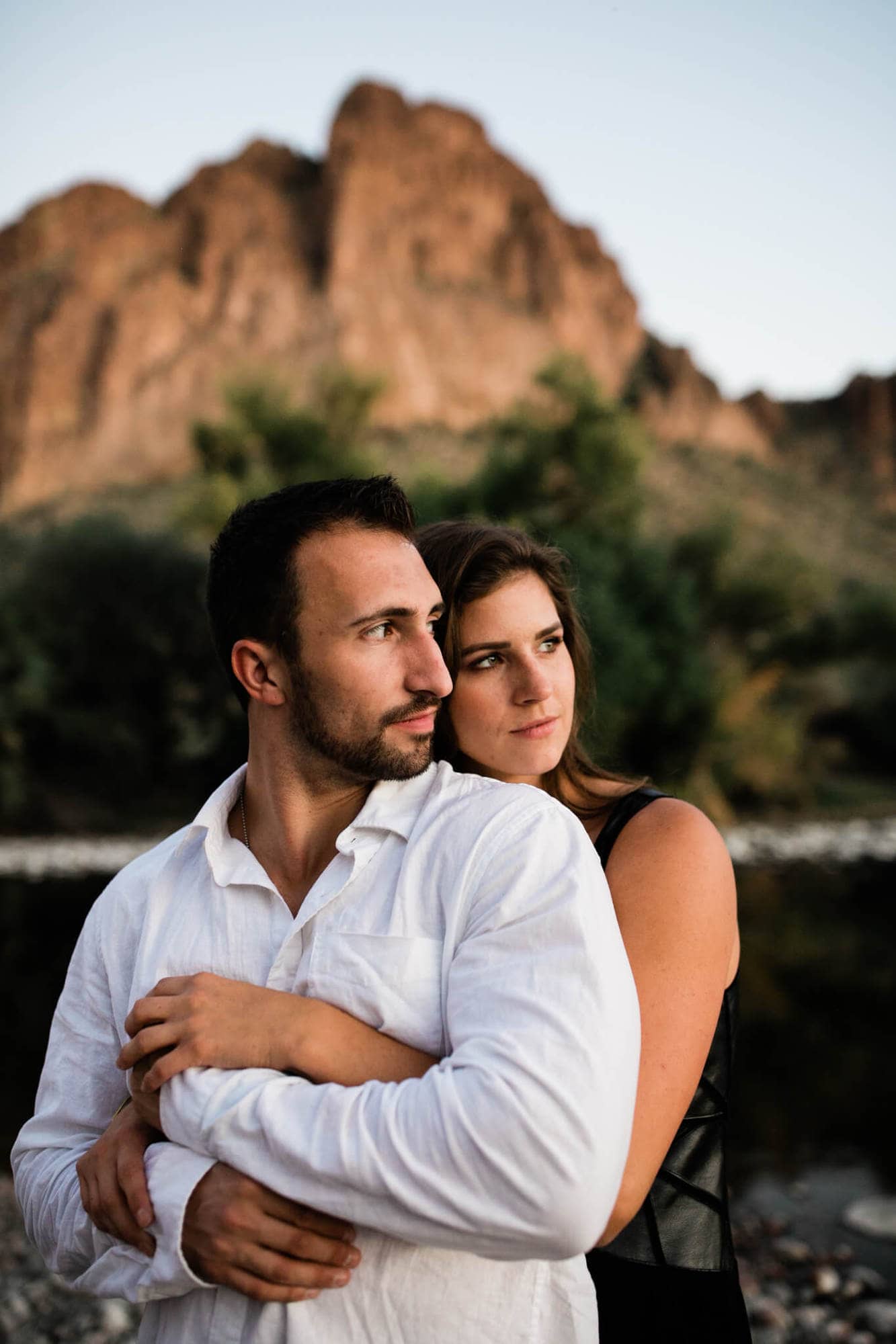 The couple walks along the Salt River during their desert engagement session.
