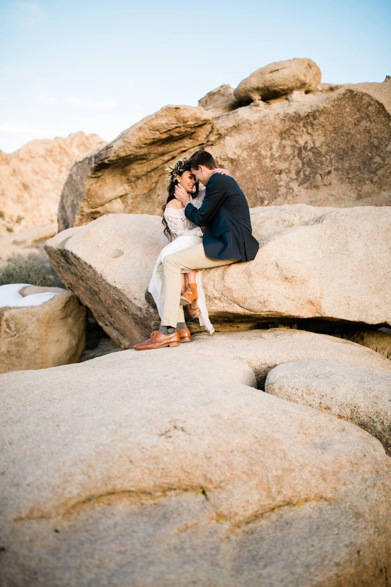 During their Joshua Tree elopement, the couple sits atop a pile of desert boulders.