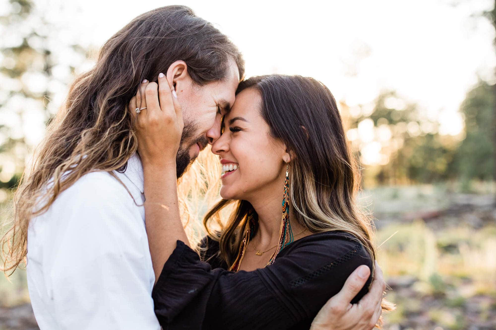 The couple laughs during their rad forest engagement session.
