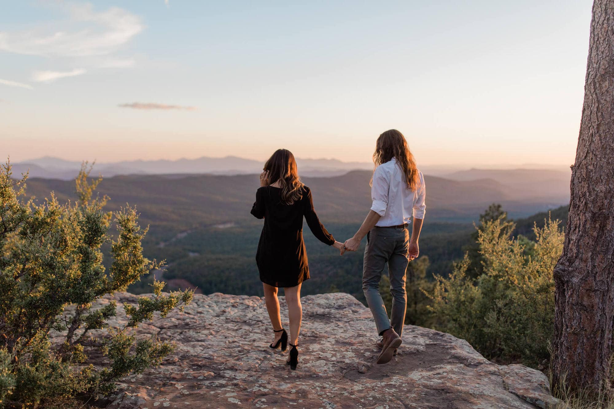 Hand in hand, the couple walks to the edge of the Mogollon rim during their adventurous engagement photo session.