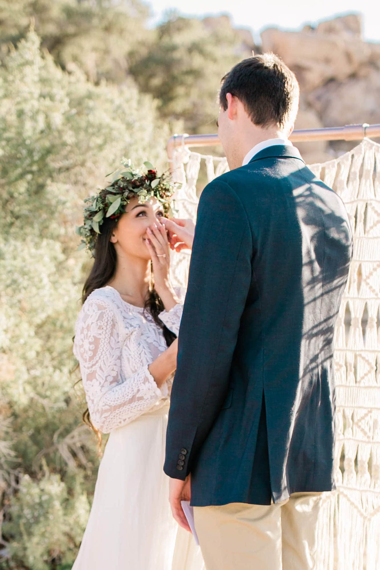 The groom wipes away his bride's tears tears during his joshua tree elopement.
