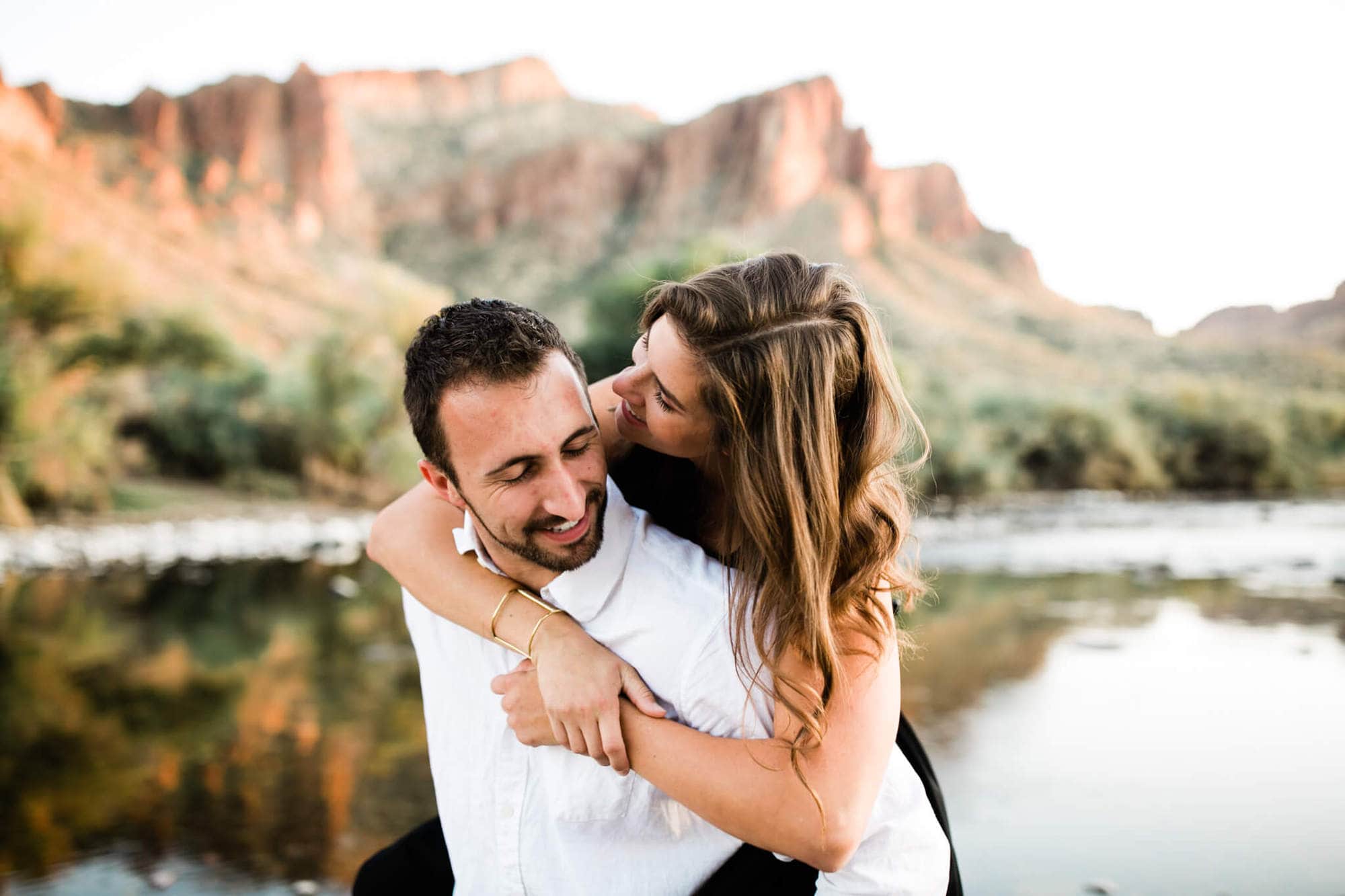 Adventurous couple snuggle with the Bulldog Cliffs and Salt River winding behind them.