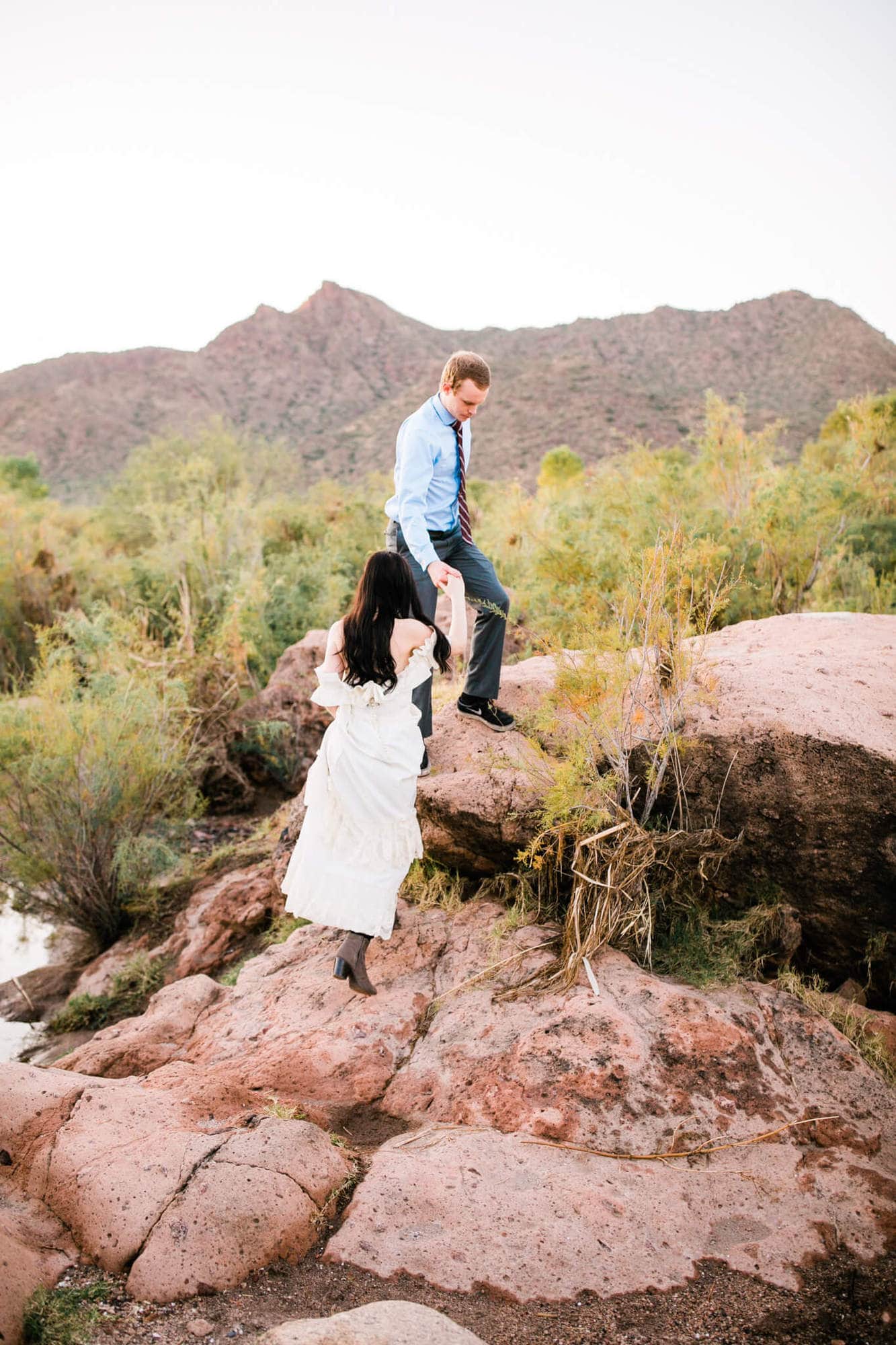 Married couple climbs rocks along the Salt River