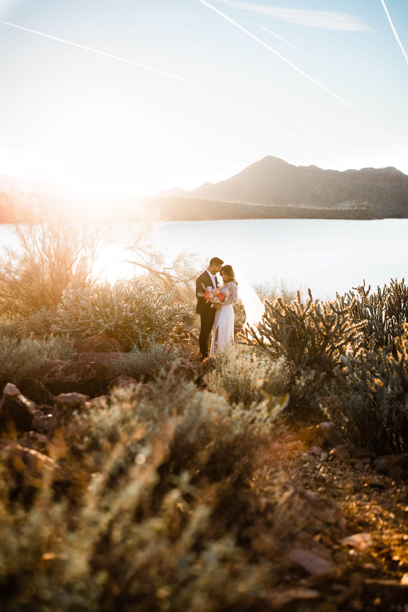 Bride and groom embrace at Saguaro Lake.