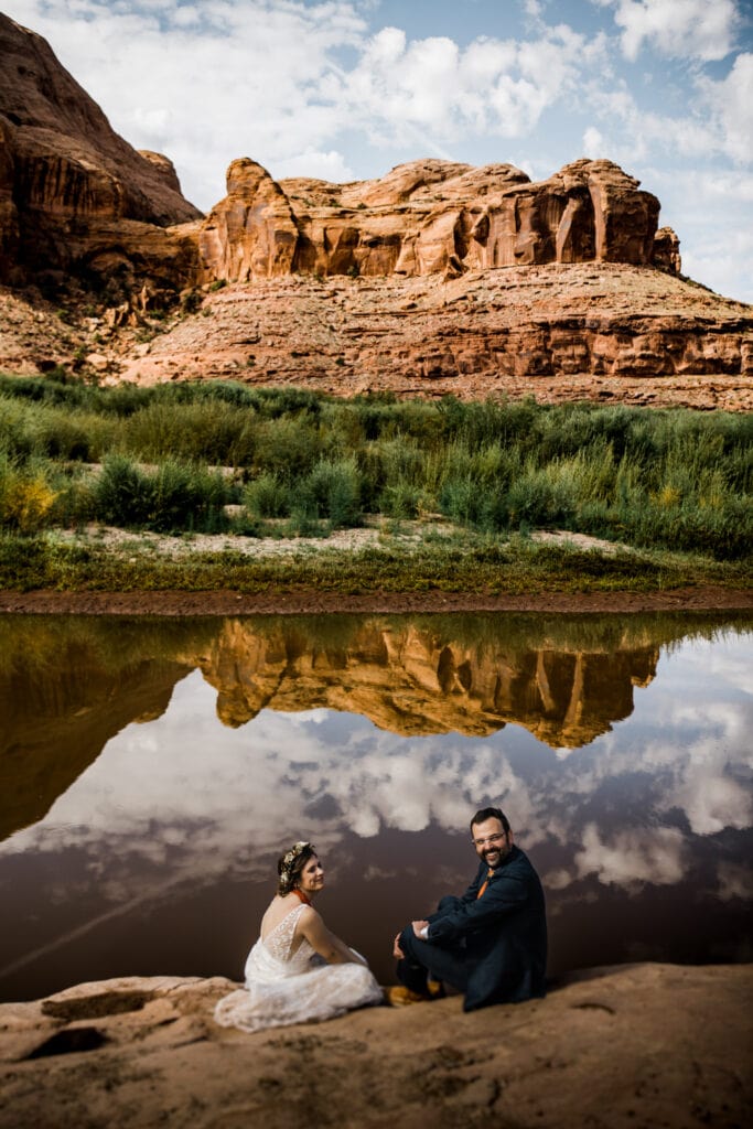 newlyweds sitting by the colorado river during their elopement in Moab