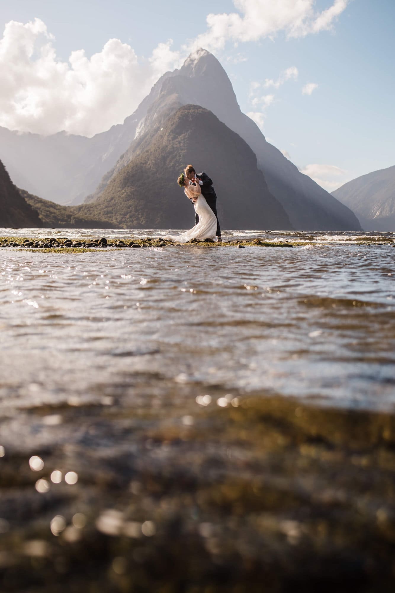 A bride and groom kiss in front of Mitre Peak during their New Zealand elopement. 