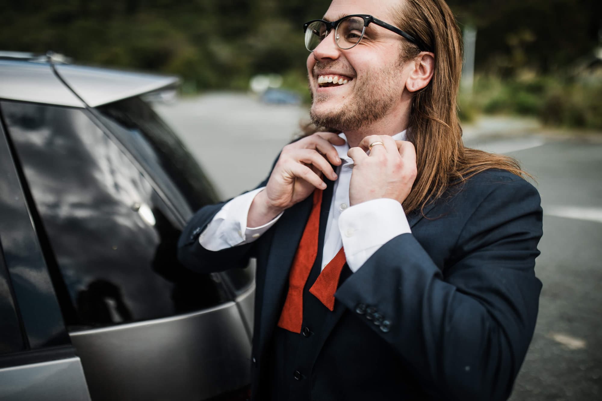 A groom ties his tie in the Milford Sound Car park. 