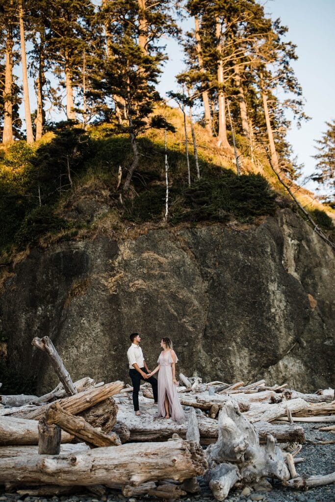 Bride and groom stand on driftwood during their Ruby Beach elopement in Olympic National Park
