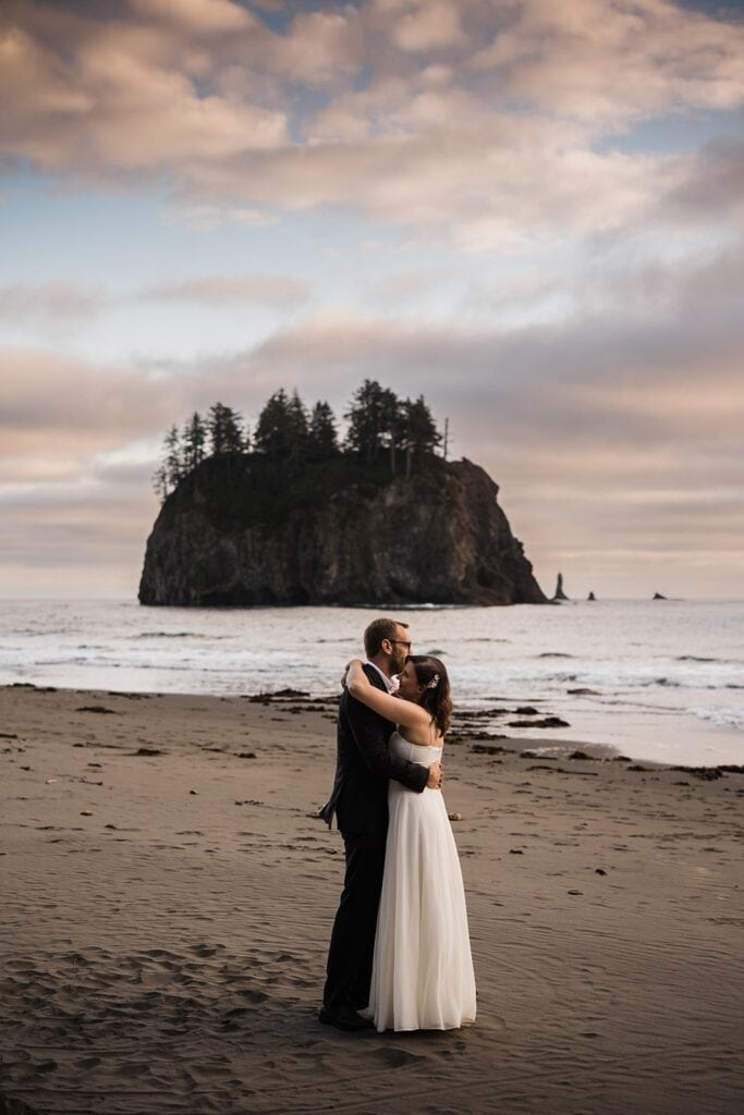 Groom kisses bride on the forehead during their elopement at Second Beach