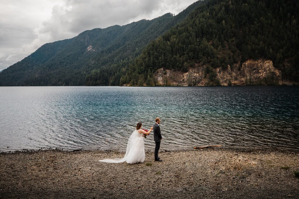 Bride taps groom on the shoulder during their Lake Crescent elopement in Olympic National Park