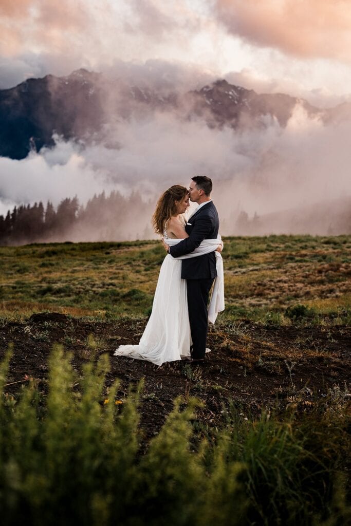 Groom kisses bride on the forehead during their Olympic National Park elopement
