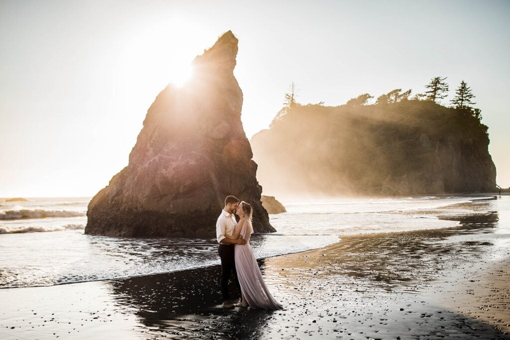 Bride and groom kiss in front of a sea stack rock at their Ruby Beach elopement