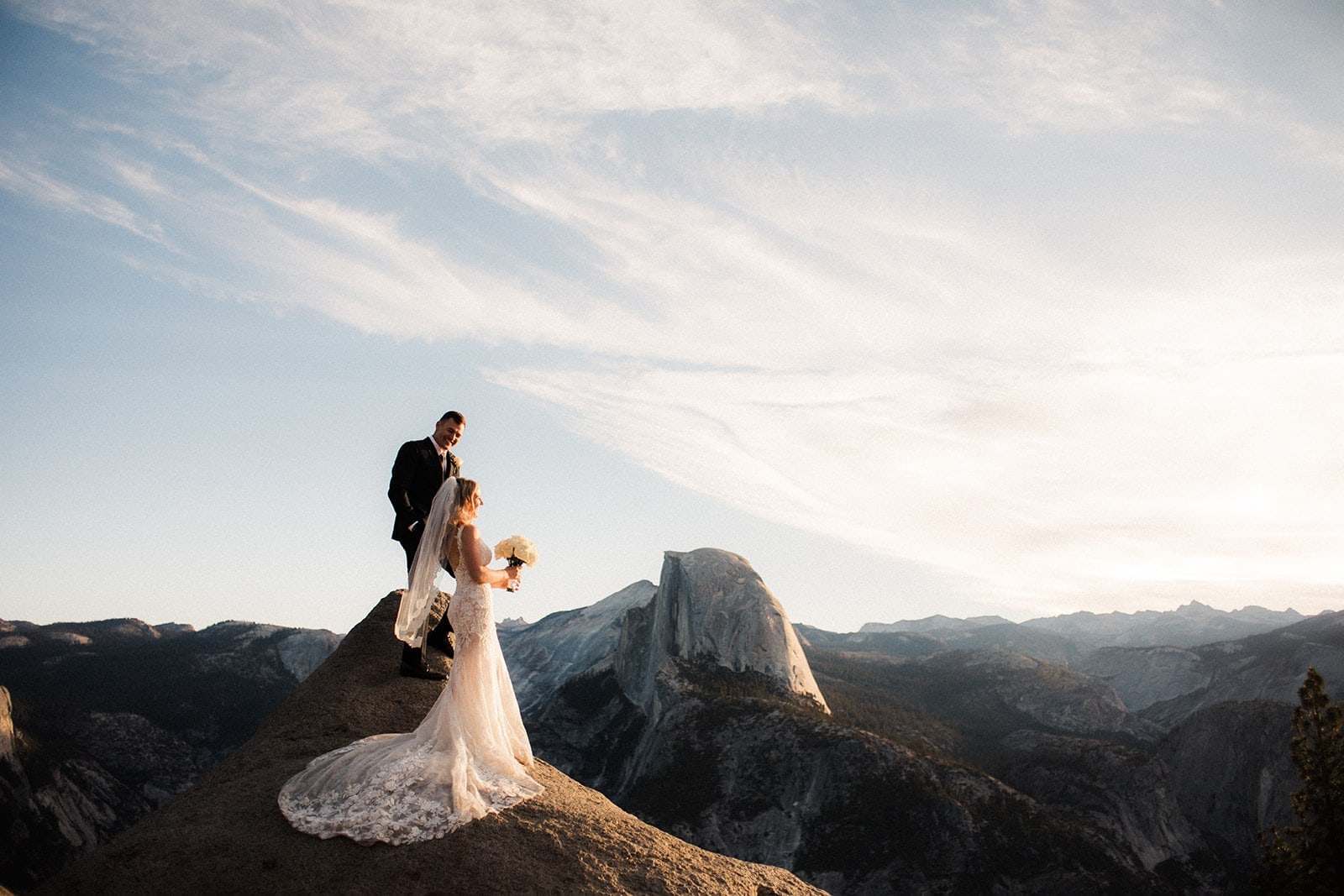 Bride and groom stand on a lookout at during their elopement Glacier Point, Yosemite.