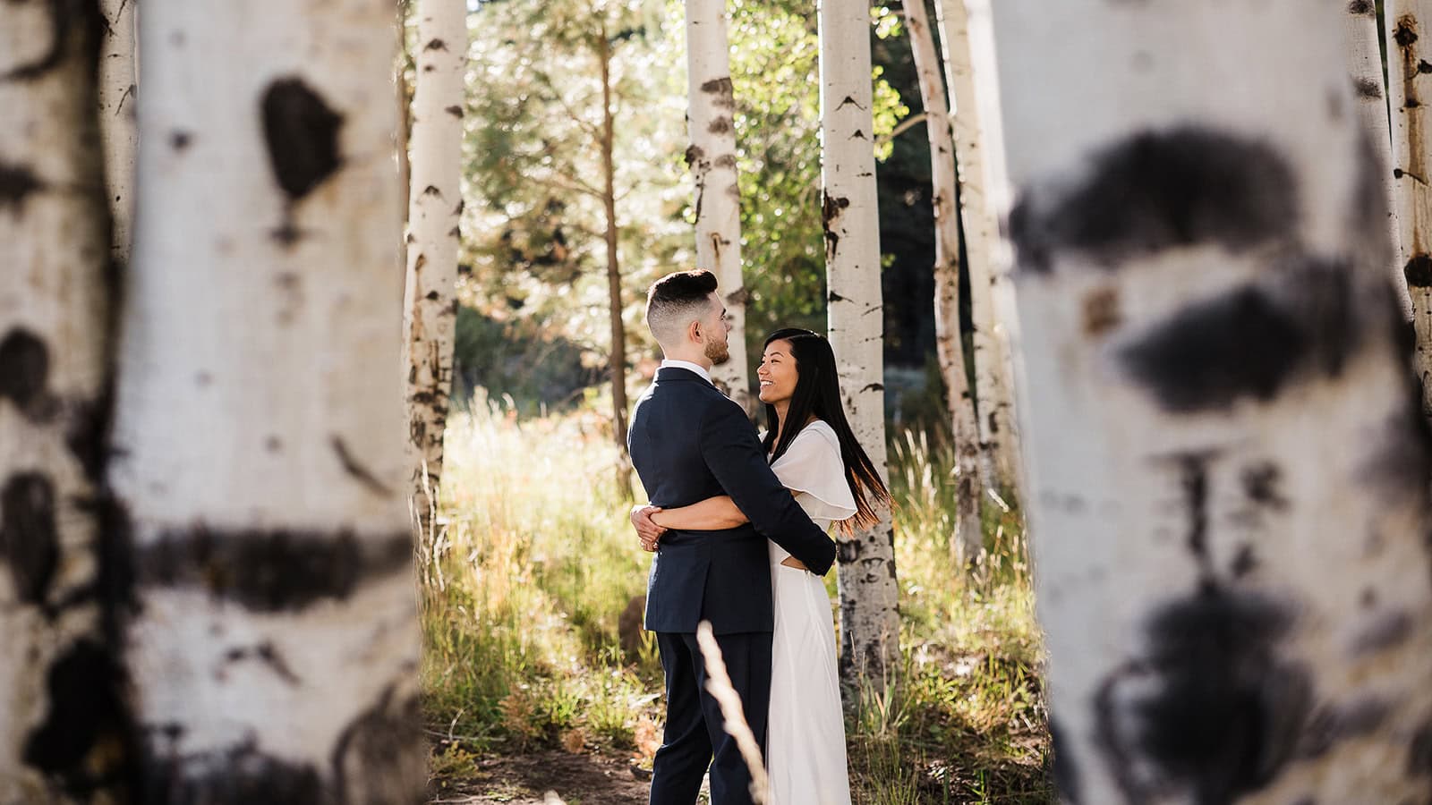 newlyweds hugging in a grove of aspen trees in the fall.