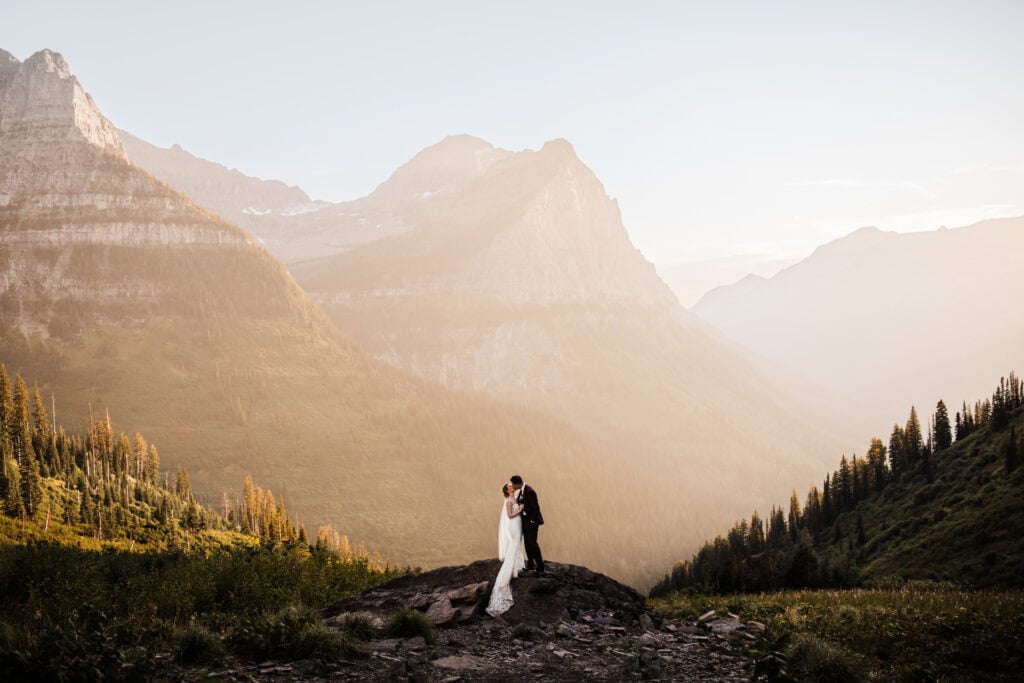 A bride and groom kiss at sunset during their elopement in Glacier National Park. 