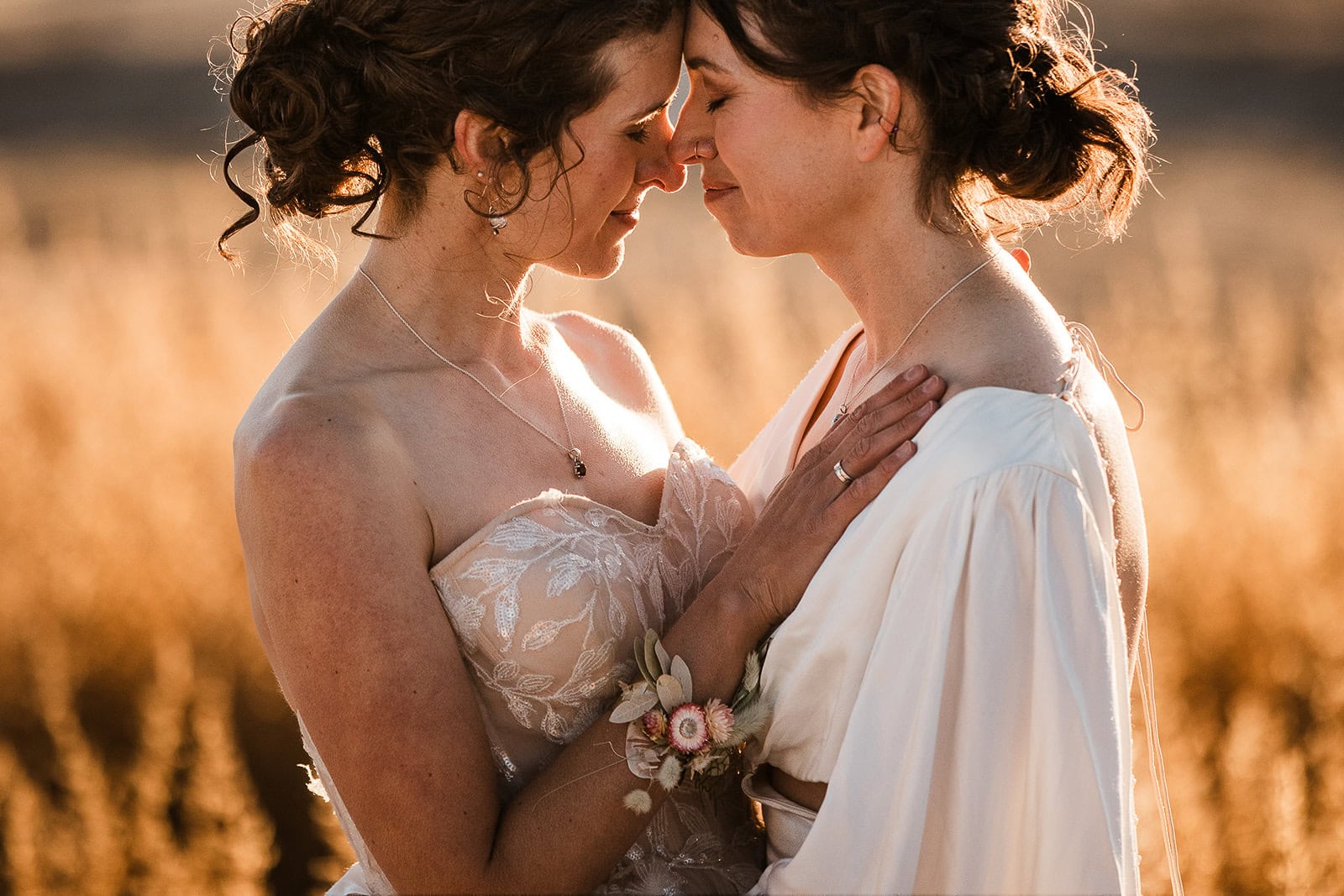 newlyweds hugging at sunset as the golden hour glow makes the whole scene feel warm.