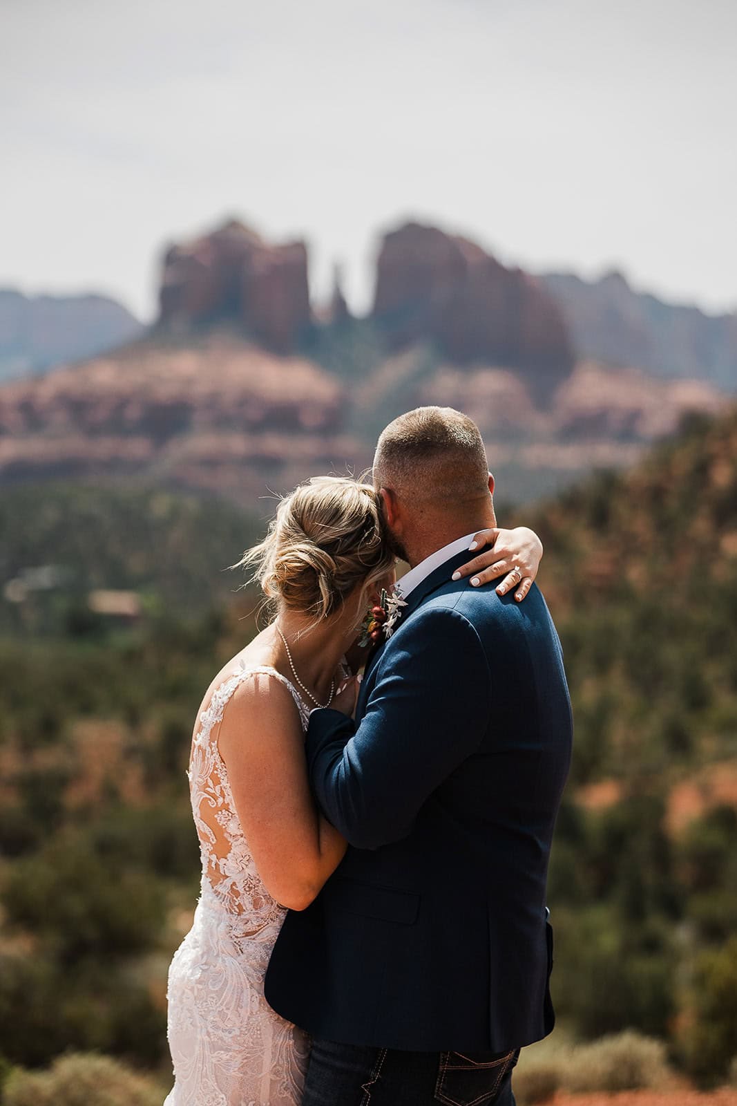 newlyweds hugging while taking in the views of Sedona.
