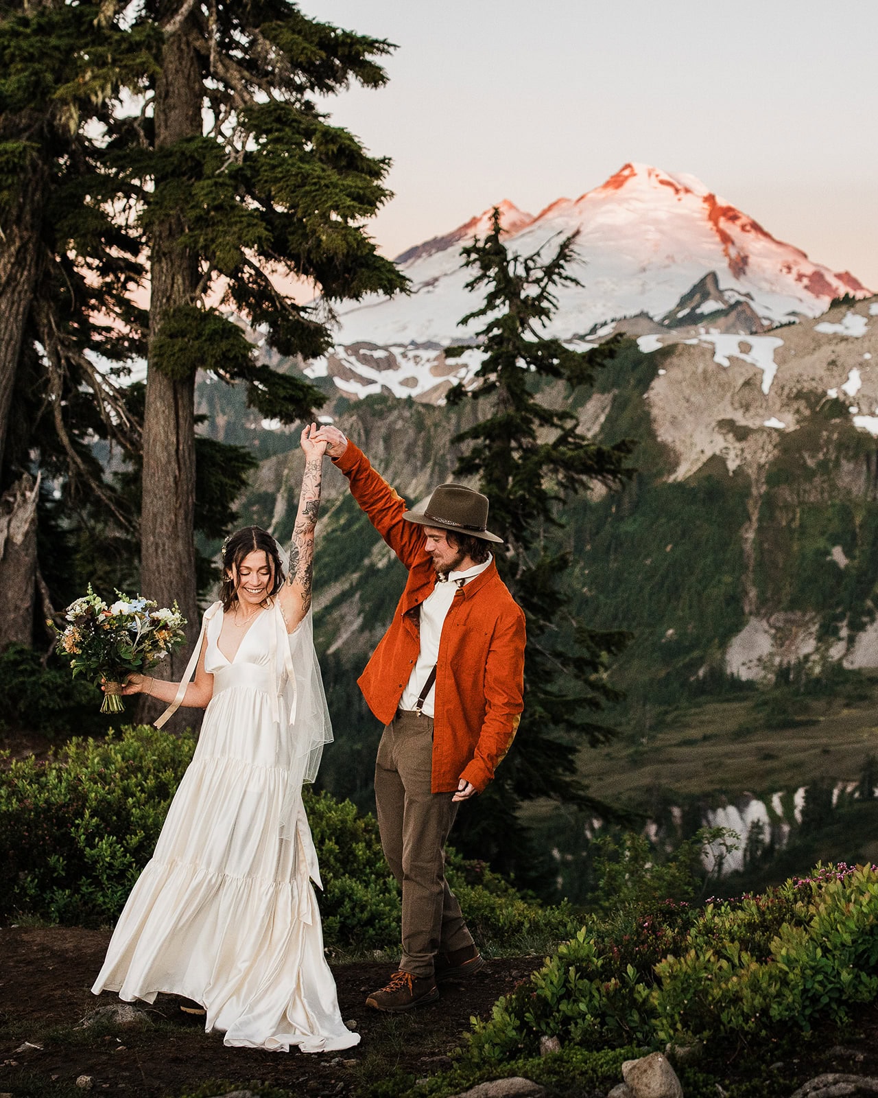 newlyweds dancing in the shadow of a mountain.