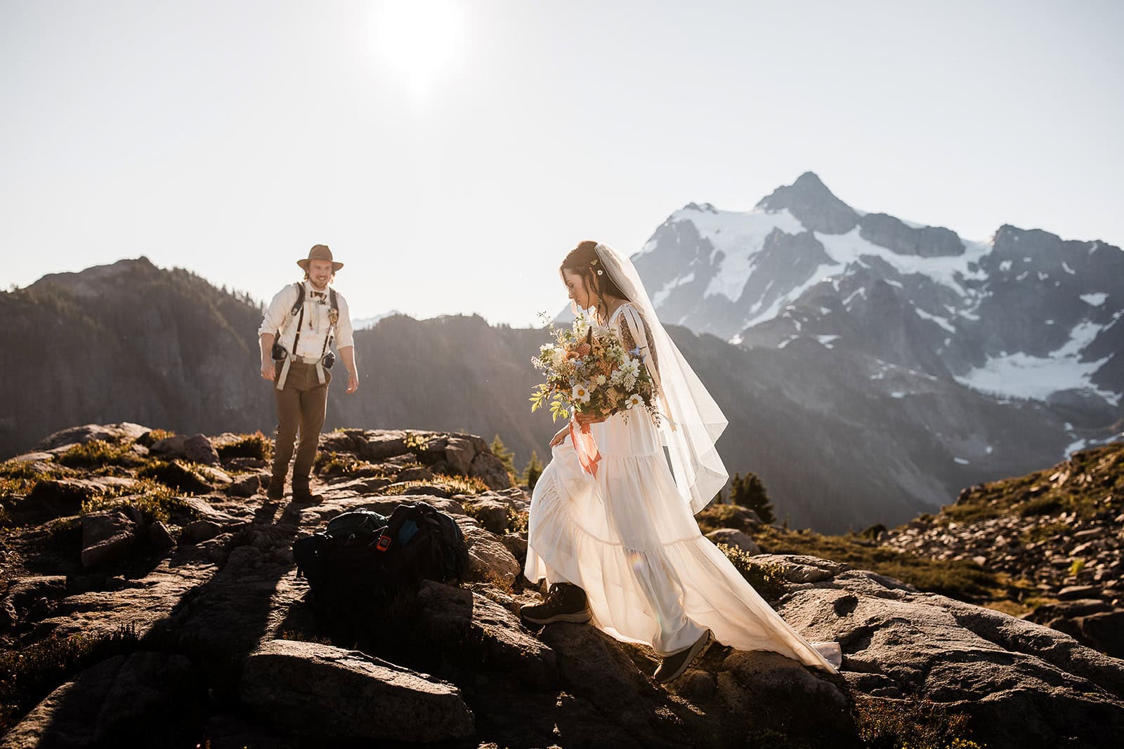newlyweds hiking up a mountainside during their elopement.