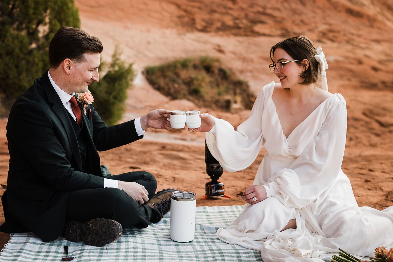 newlyweds having coffee in the desert during a picnic