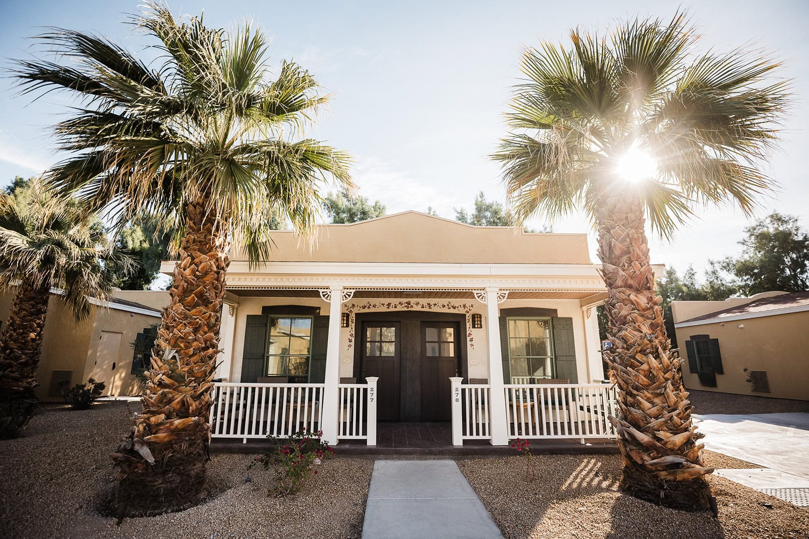 a hotel room with palm trees in front that couples can stay at when they elope in Death Valley.