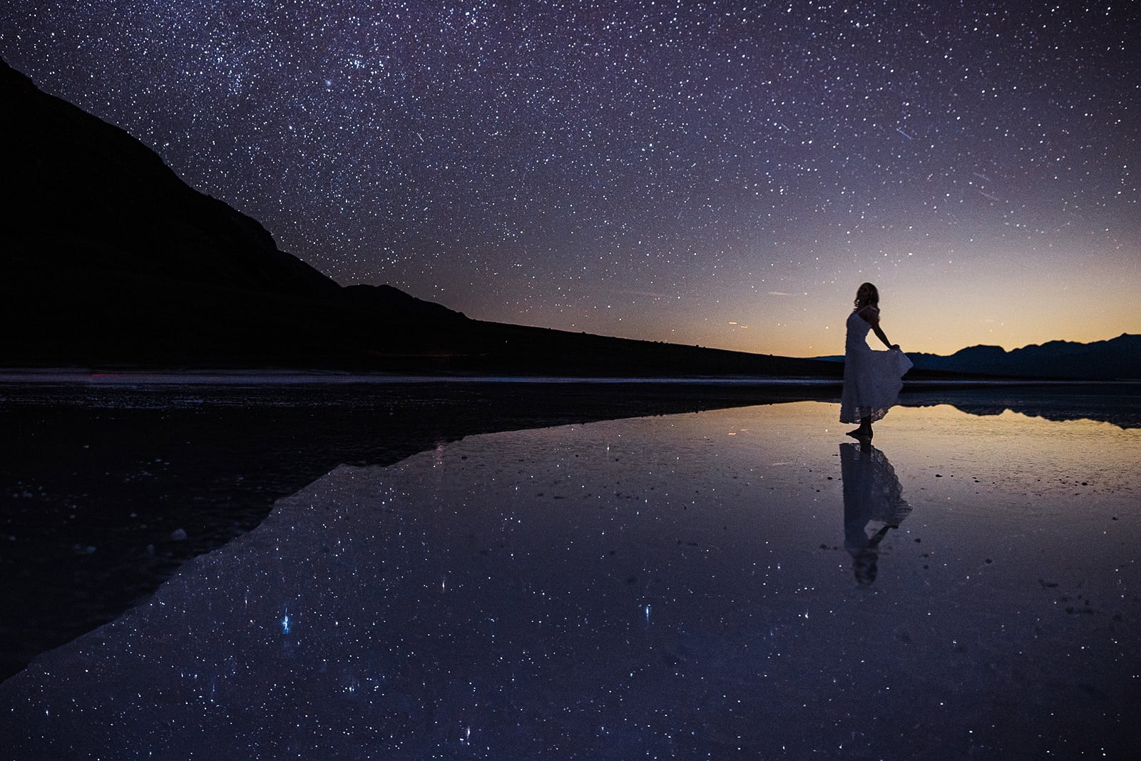 a bride dancing on lake manly at night as she chooses to elope in Death Valley.