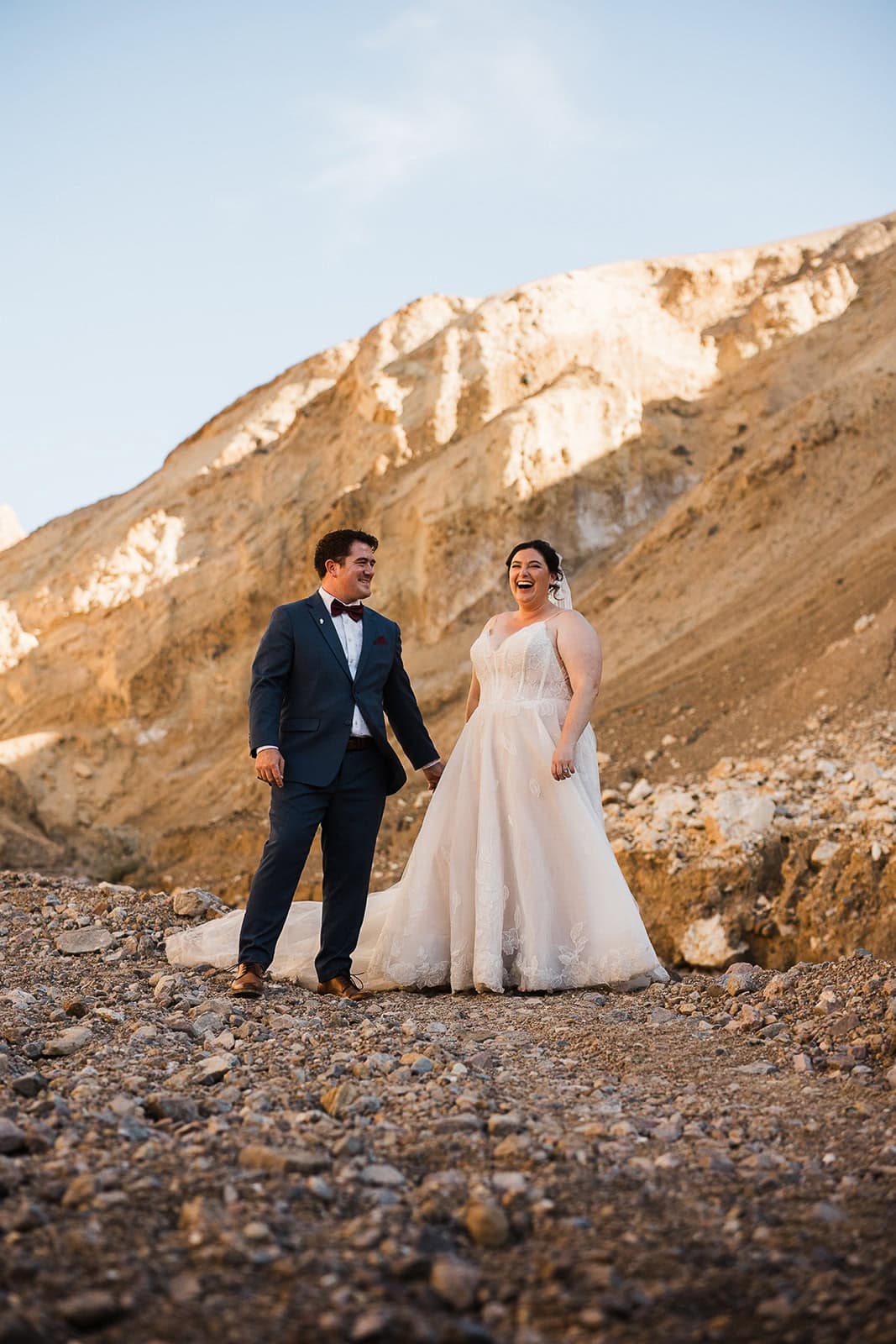 newlyweds holding hands in breakfast canyon as they elope in Death Valley.