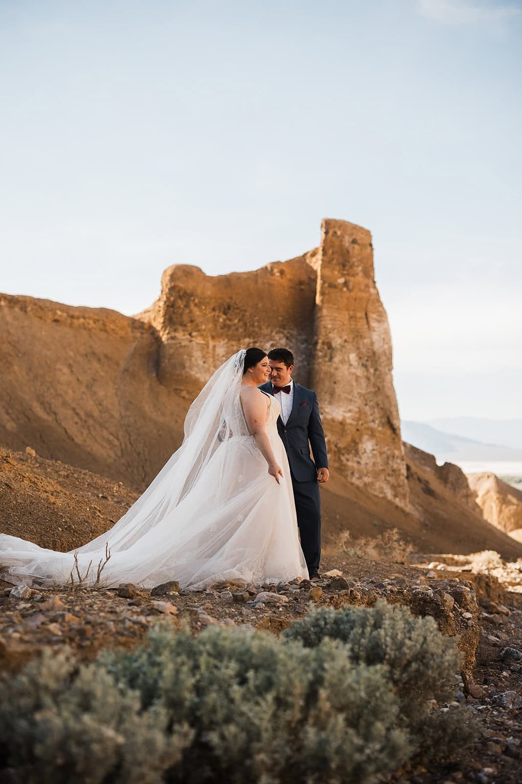 newlyweds holding hands in breakfast canyon as they elope in Death Valley.