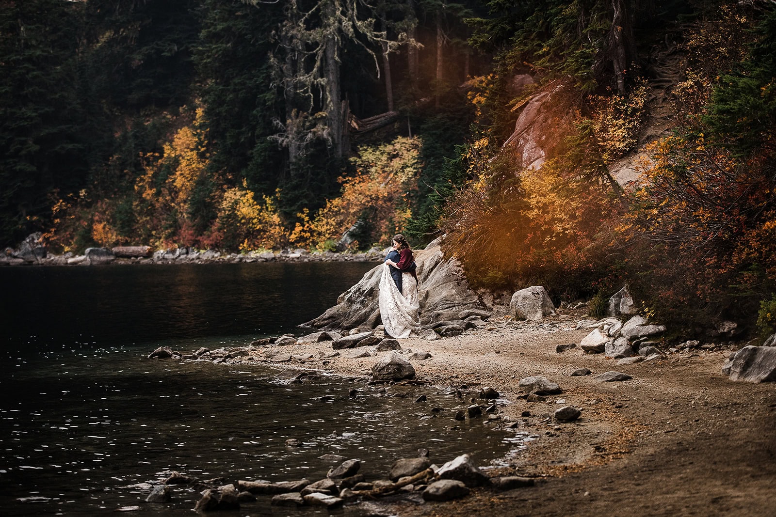 newlyweds hugging on a lakeshore in fall as they elope in Washington.