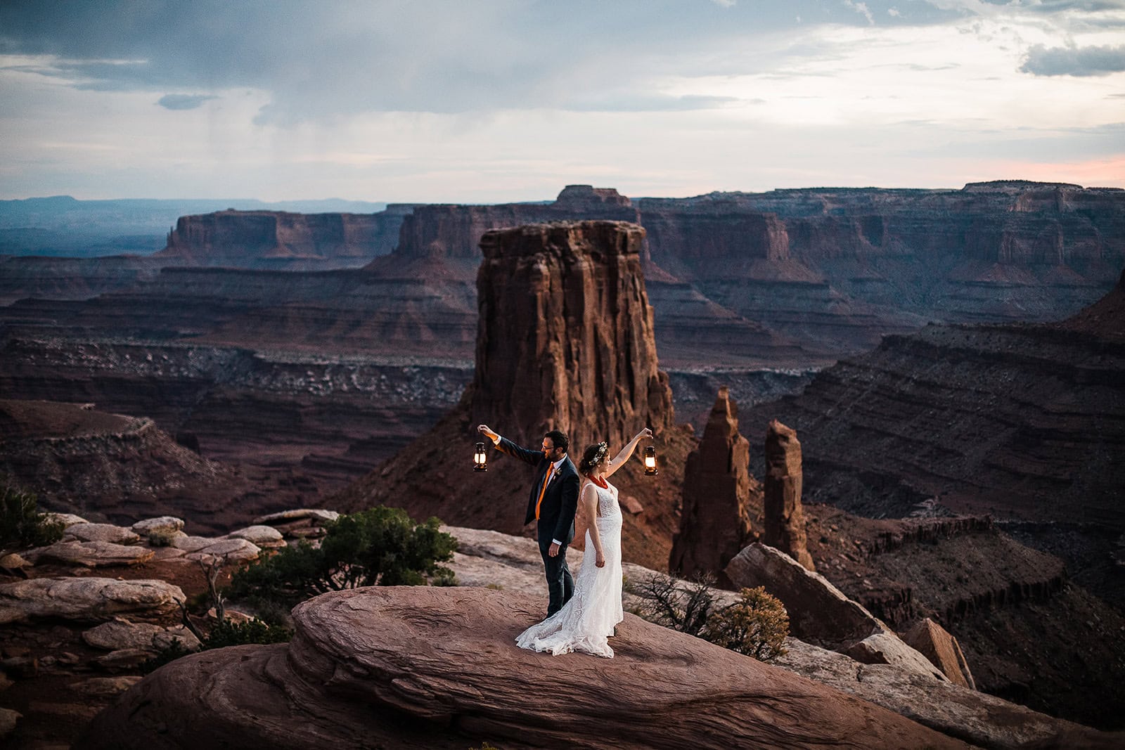 newlyweds holding up lanterns in a canyon, one of the many places to elope in Moab.