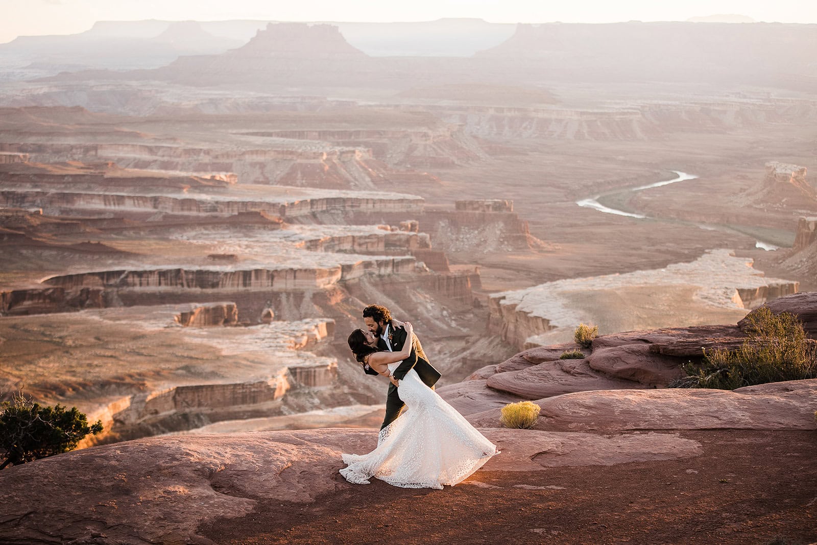 Newlyweds dancing on a canyon ledge, one of the many places to elope in Moab.