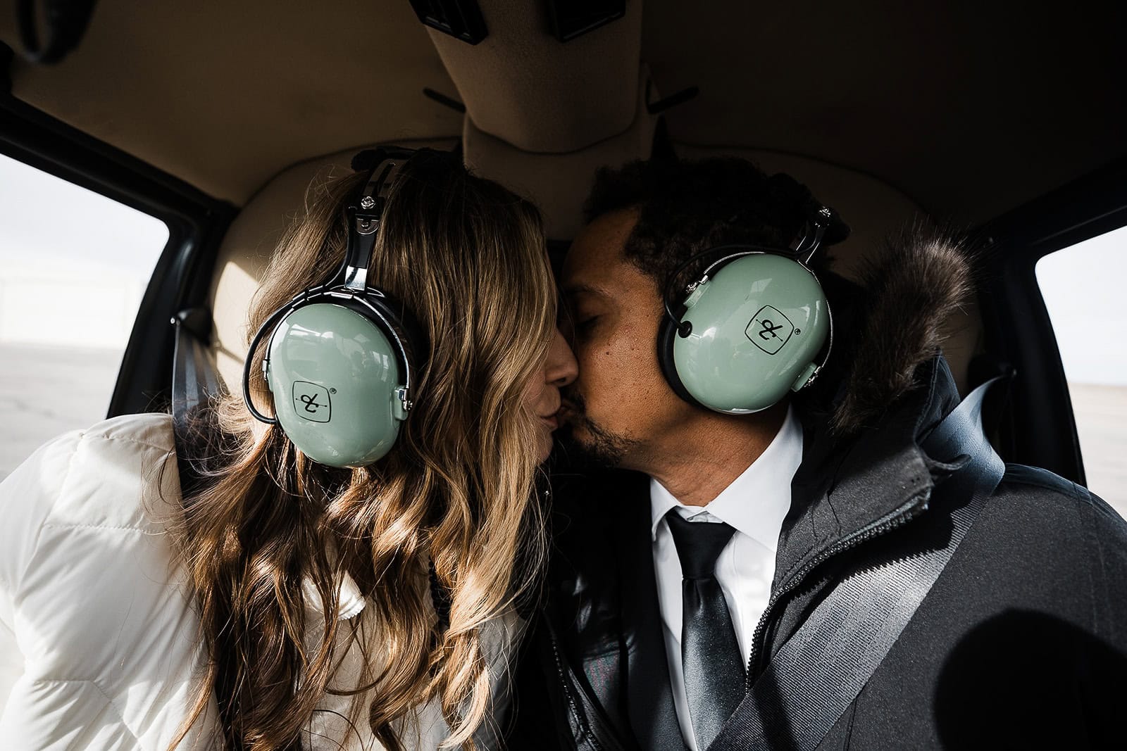 newlyweds kissing inside of a helicopter.