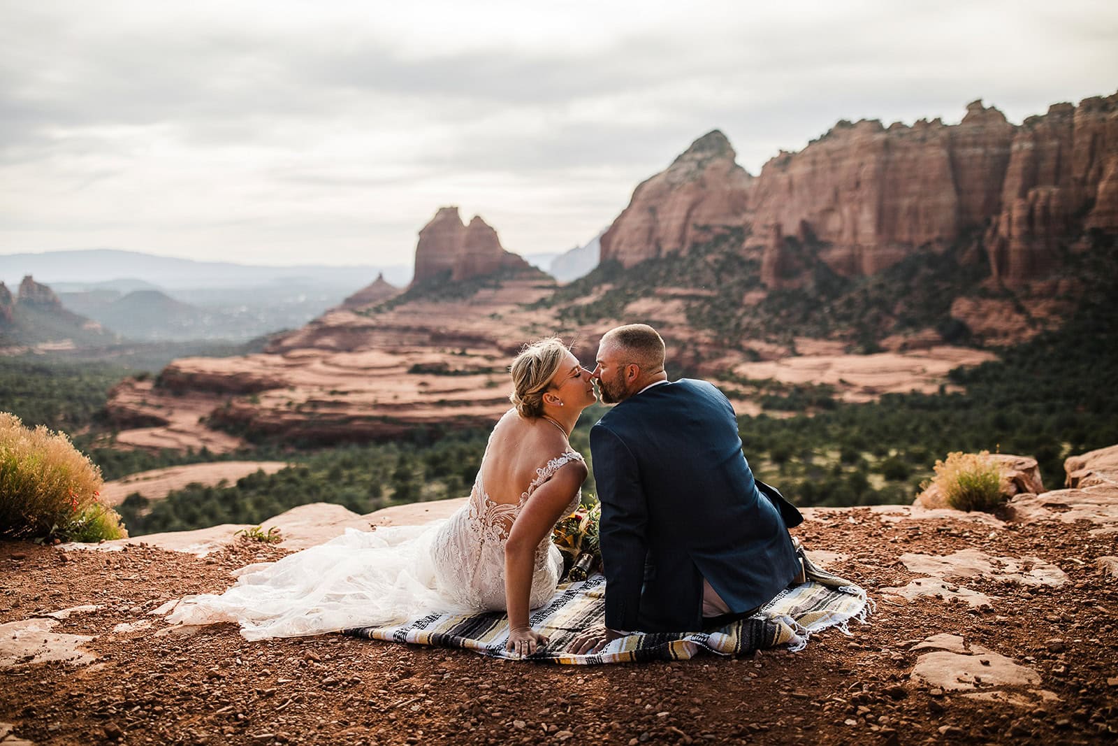 newlyweds kissing on a sedona cliffside after getting their marriage license in arizona.