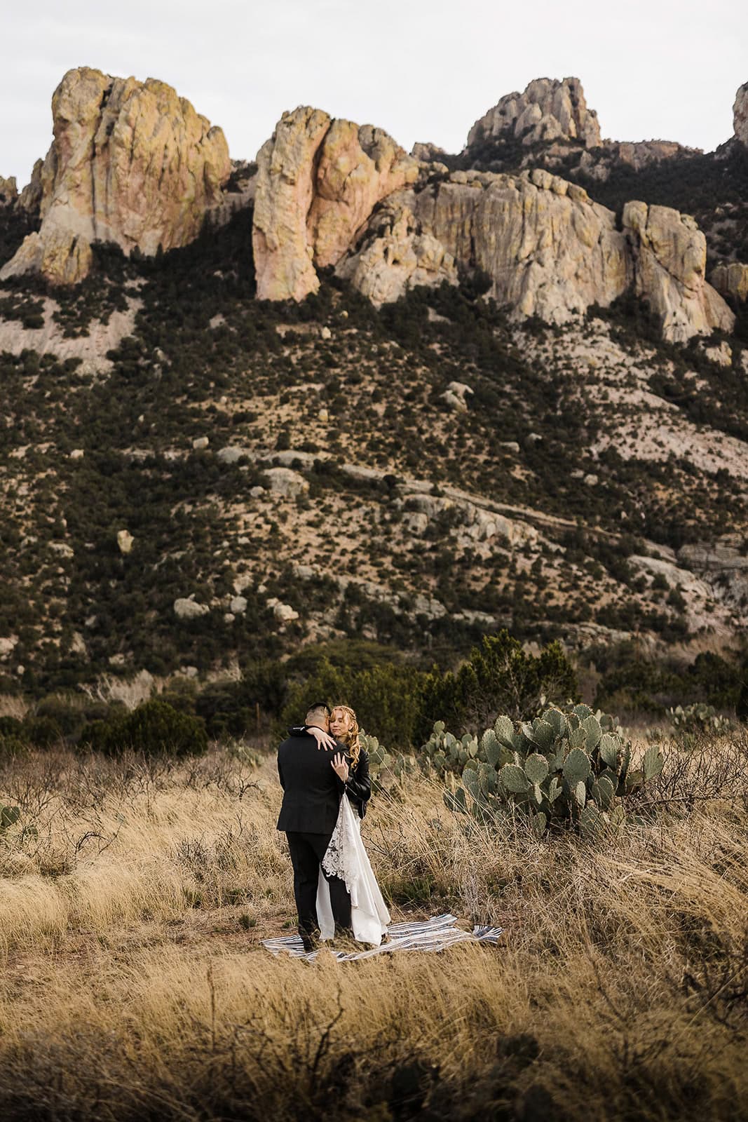 newlyweds kissing in front of a mountainside after getting their marriage license in arizona.