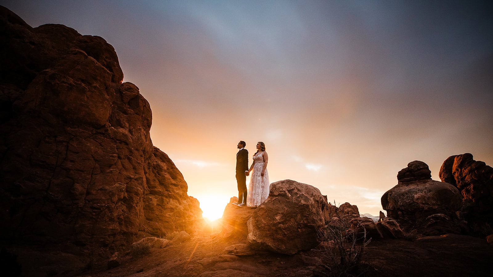 Newlyweds holding hand during golden hour in moab.