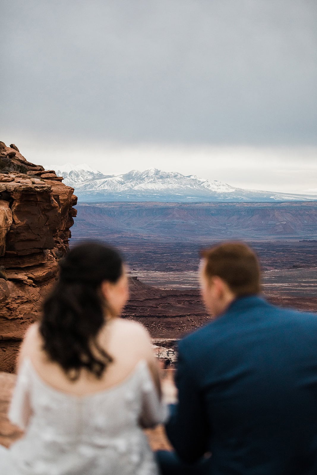 Newlyweds enjoying the view of canyons and mountains in winter, one of the best seasons to consider when deciding when to elope in Moab.
