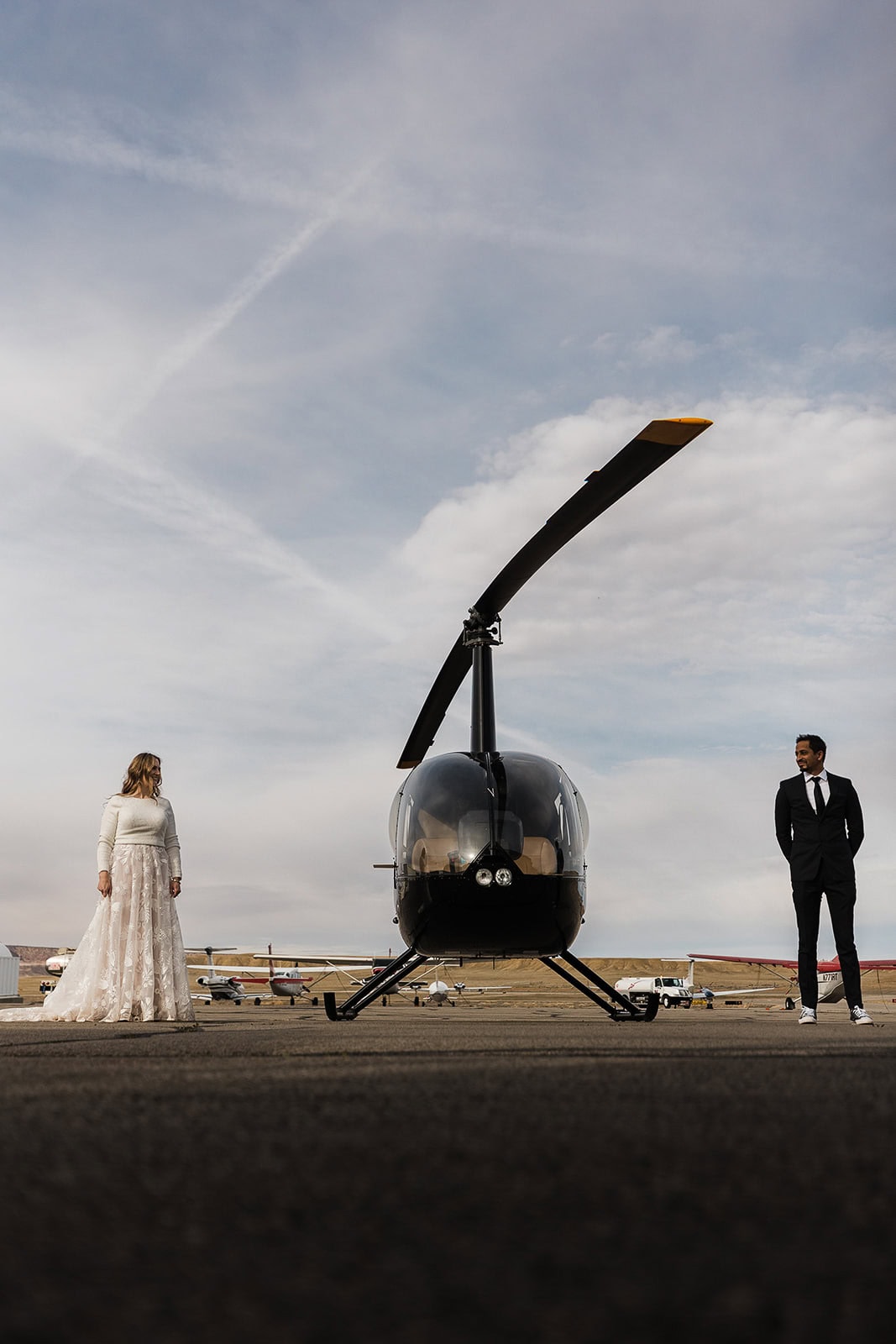 newlyweds standing next to a helecopter, an expense you consider when answering the question "how much does it cost to elope"?