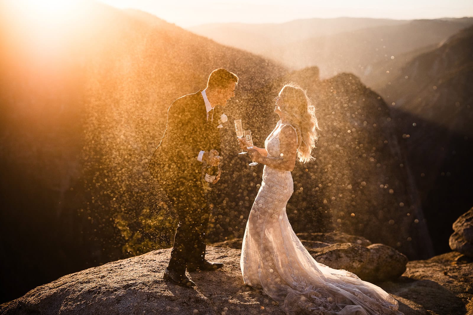 newlyweds on a mountain popping champagne, an expense you consider when answering the question "how much does it cost to elope"?