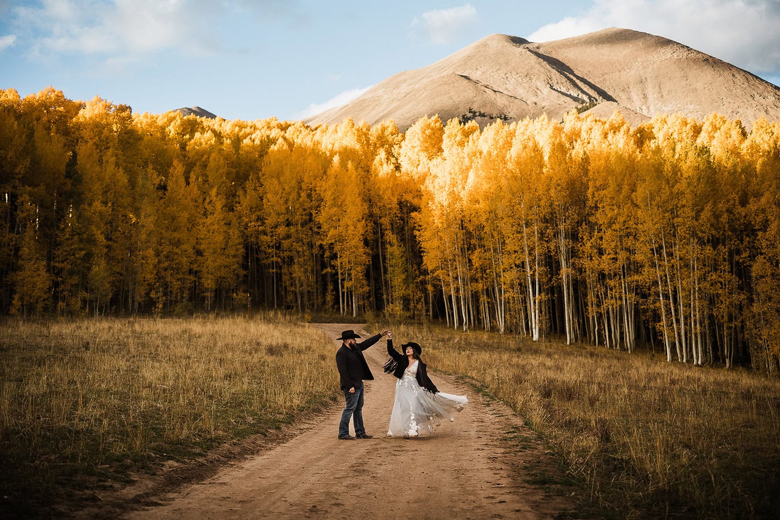 newlyweds dancing in front of fall aspen leaves during their wedding in the La Sal Mountains.