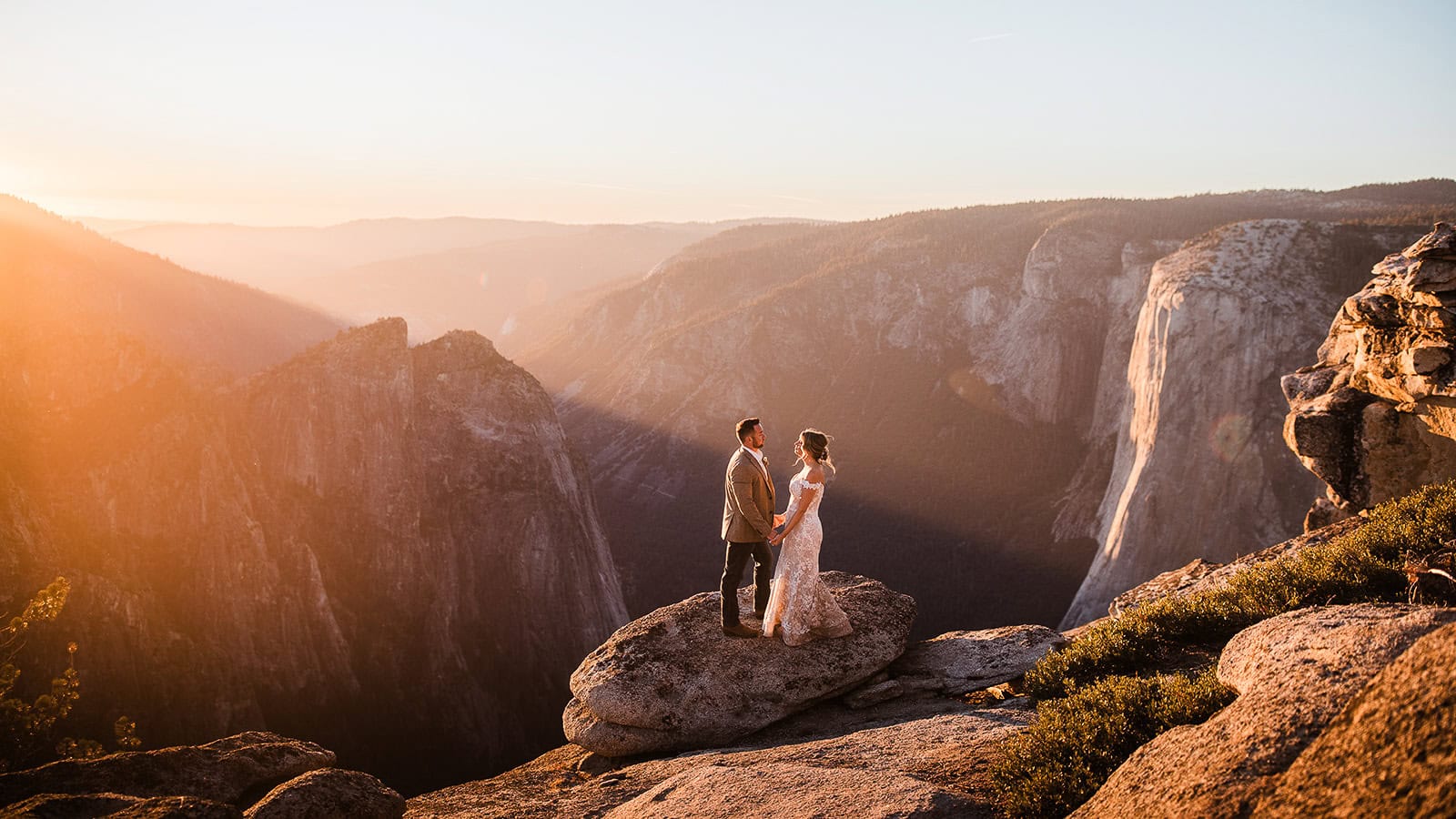 newlyweds holding hands at taft point at sunset during their Yosemite micro wedding.