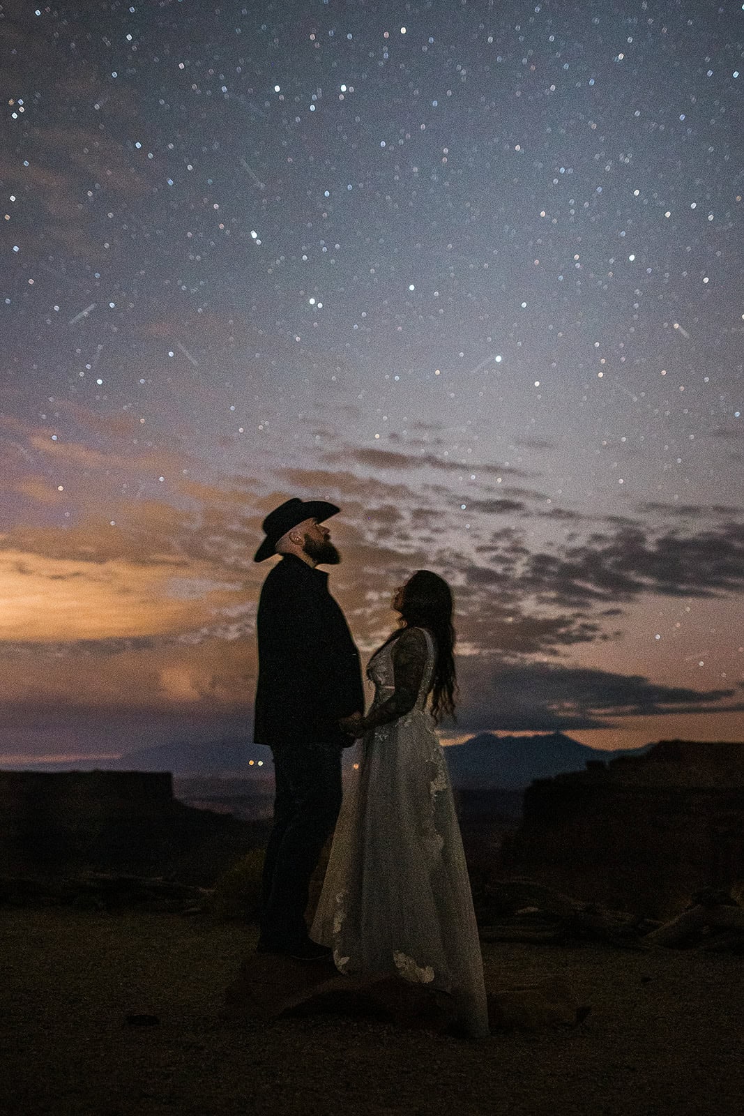 newlyweds holding hands looking at the stars.