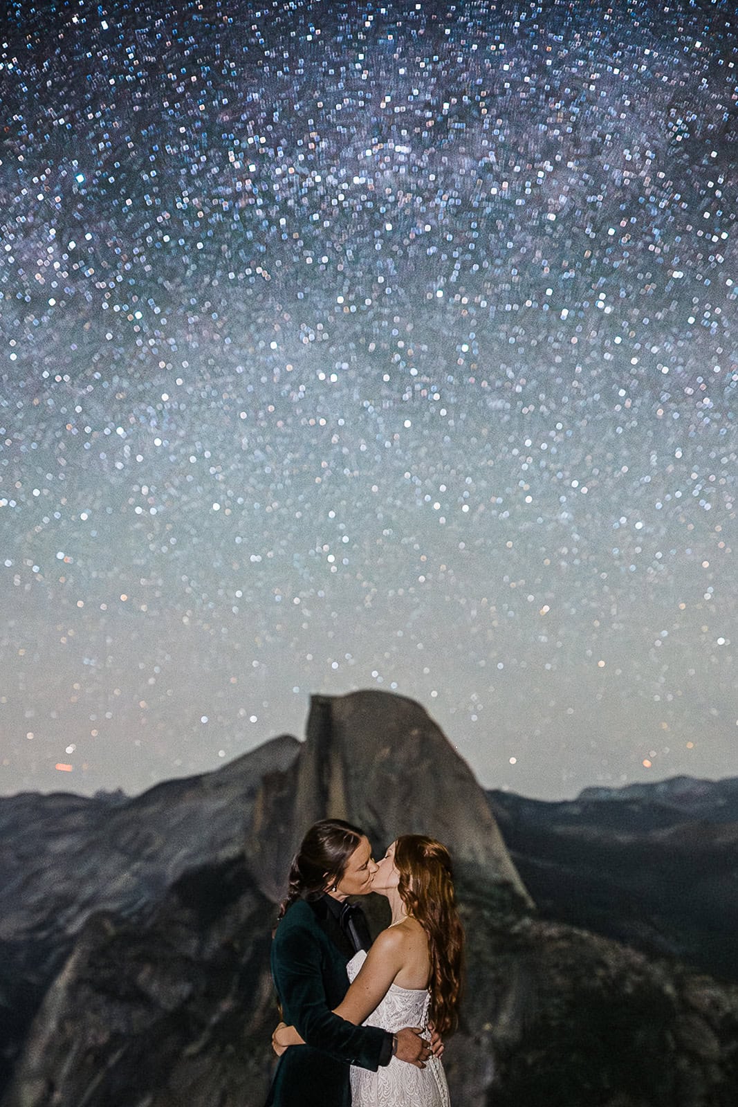 Newlyweds kissing under the stars at Glacier Point, one of the best Yosemite wedding locations.