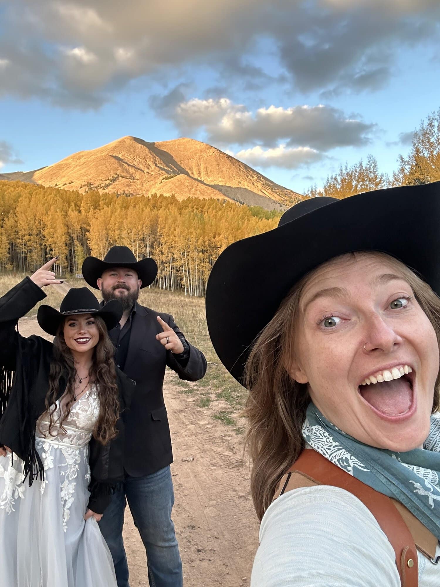 newlyweds pointing at a mountain with Aimee Flynn.