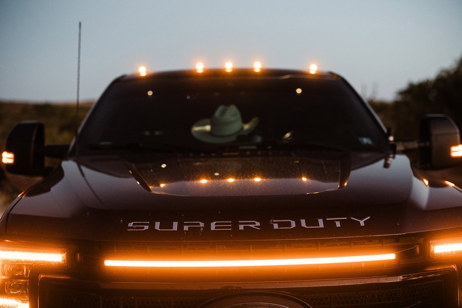 the front of a large truck with the headlights on.