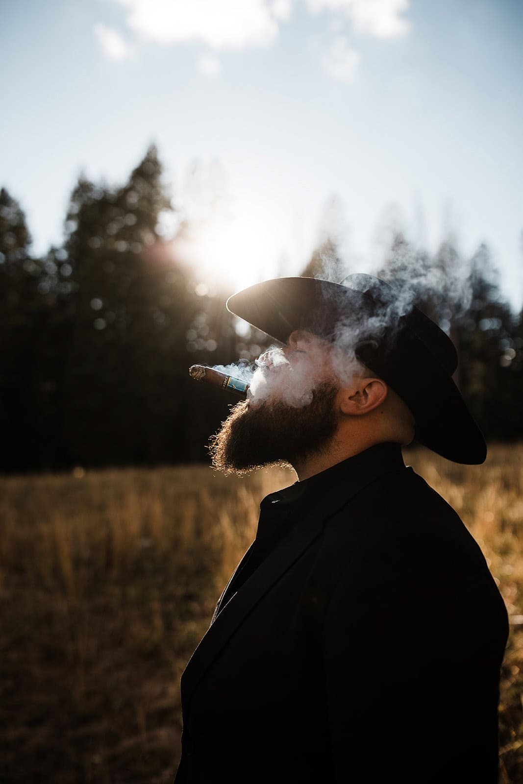groom smoking a cigar during their wedding in the La Sal Mountains.
