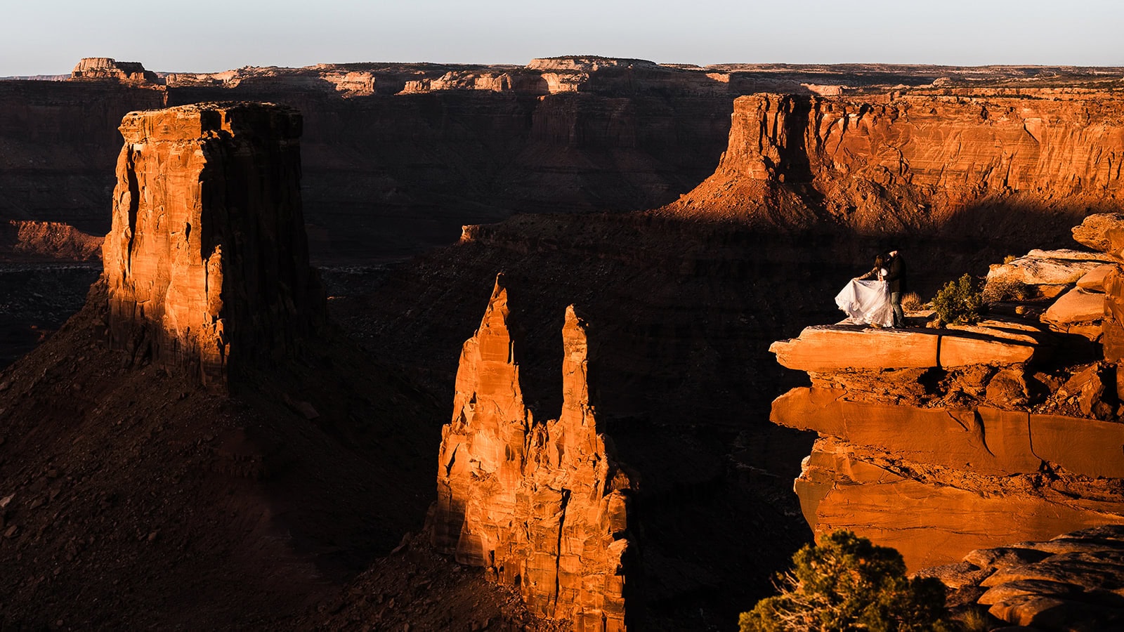 newlyweds dancing at the edge of a canyon in Moab.