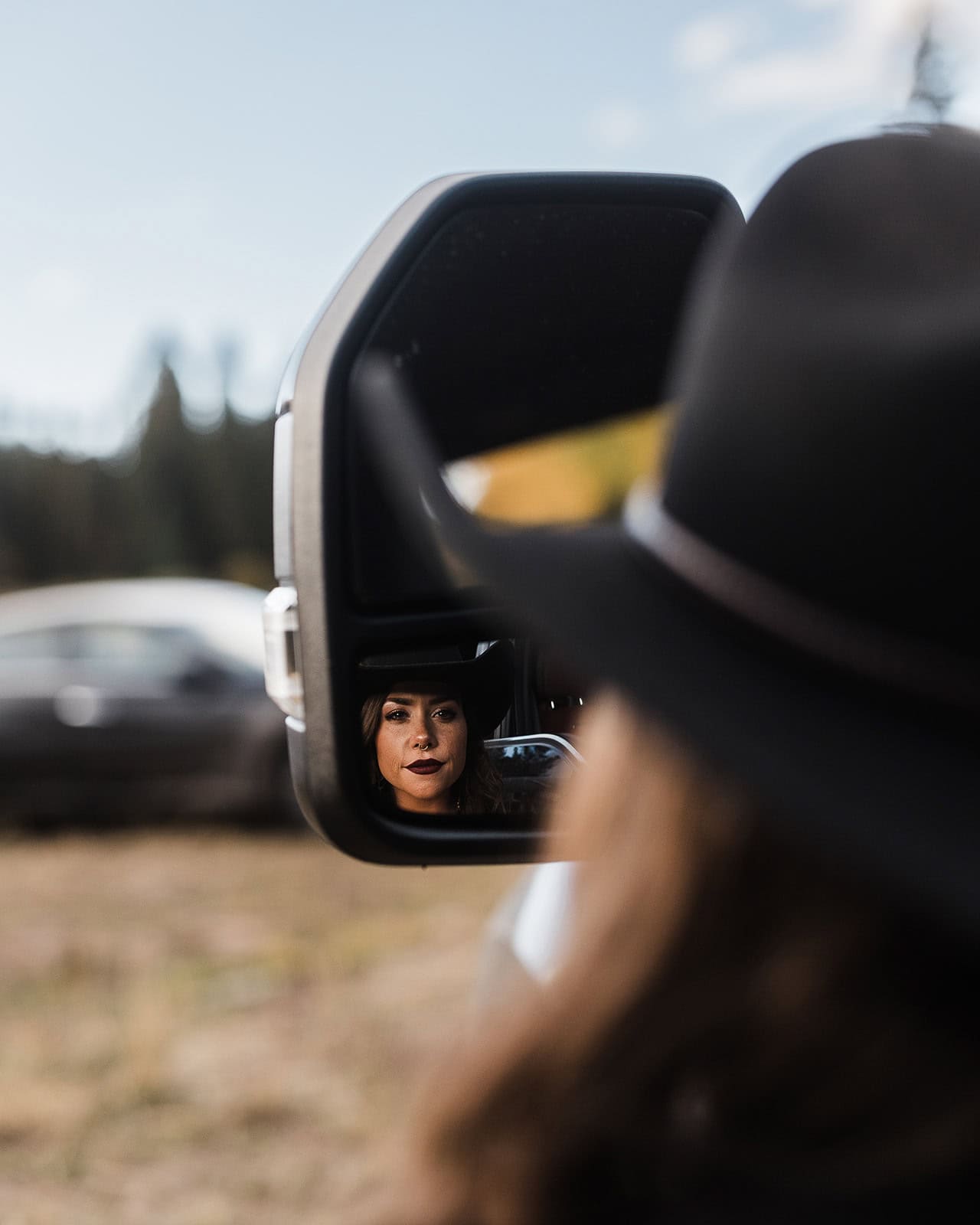 the bride reflecting out of a car side mirror during their wedding in the La Sal Mountains.